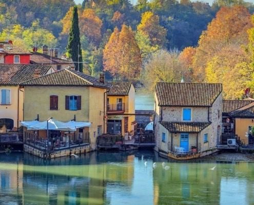 Scenic view of Borghetto sul Mincio, showcasing the medieval architecture surrounded by lush greenery.