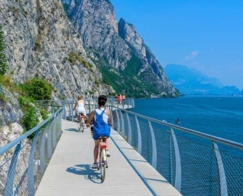 Girls riding bikes on the cycling path of Limone sul Garda.