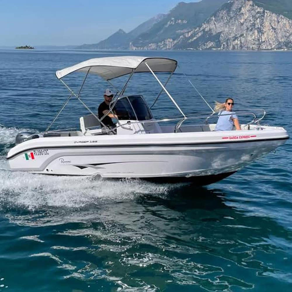 Couple driving a rented boat on Lake Garda.