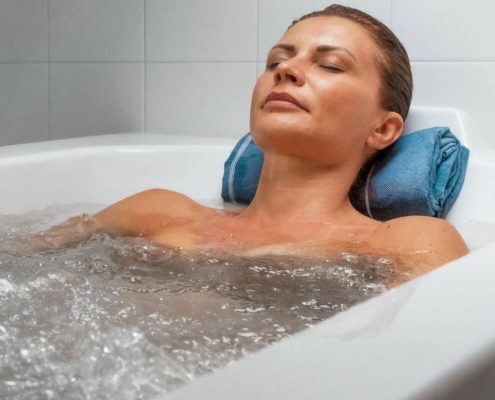 A woman lies in a therapeutic bath in Terme di Comano Wellness Center near Lake Garda.